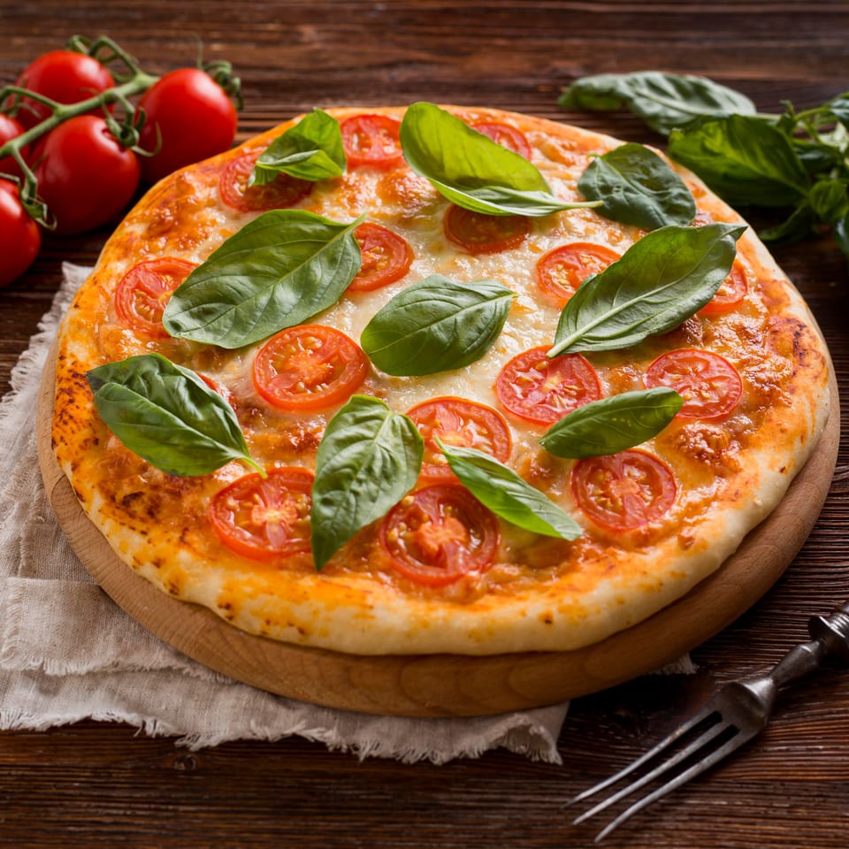 Runner Pizza Stoughton's Margherita pizza with fresh basil, sliced tomatoes, and melted cheese on a wooden board.